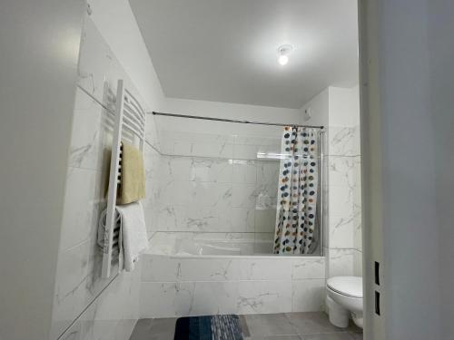 La salle de bains blanche est pourvue d'une baignoire et de toilettes. dans l'établissement Antibes Old Center Charming Brand New Apartment, à Antibes