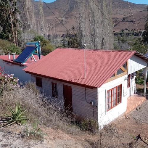 una pequeña casa con techo rojo en Cabañas Los Gordos M y M, en Ilta