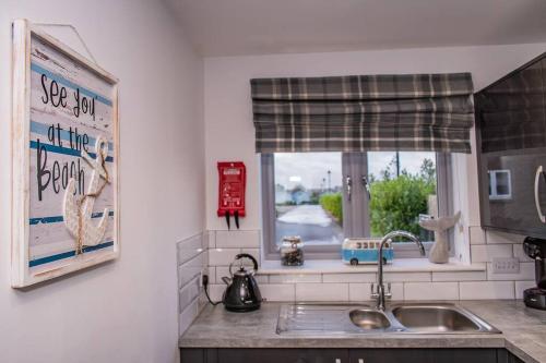 a kitchen counter with a sink and a window at Sea view The Lookout at The Bay holiday village Filey 2 bed sleeps 5 dog friendly free leisure facilities direct beach access pub and shop click to view photos in Filey
