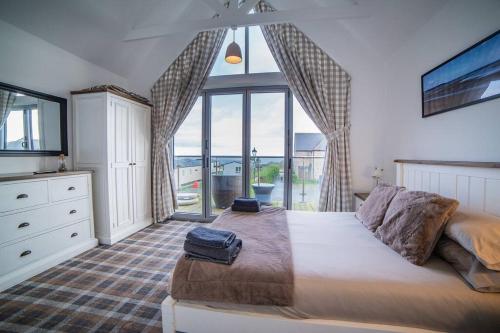 a bedroom with a large bed and a large window at Sea view The Lookout at The Bay holiday village Filey 2 bed sleeps 5 dog friendly free leisure facilities direct beach access pub and shop click to view photos in Filey