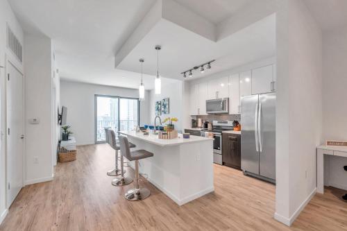 a kitchen with white cabinets and a table and chairs at Luxury 1 BR with DEN Downtown Tampa Apt - City Views, Rooftop Pool, Workspace in Tampa