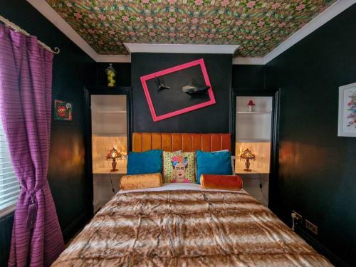a bedroom with a bed in a room with green walls at Eclectic 1BD in the Heart of Cheltenham! in Cheltenham