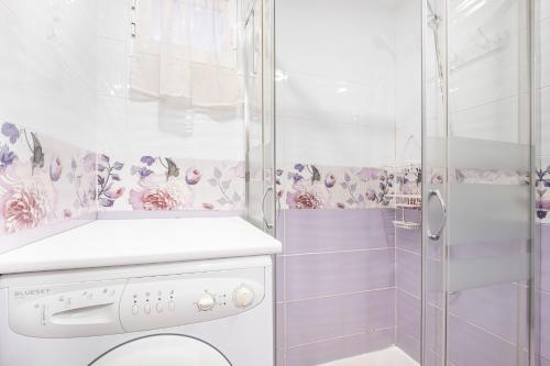 y baño con ducha y lavadora. en Don Miguel 4-F Apartment Levante Beach, en Benidorm
