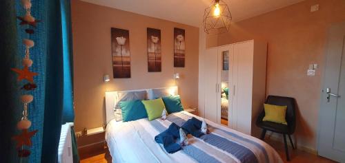 um quarto com uma cama com almofadas azuis e verdes em Le Bienvenue à Colmar, parking gratuit & balcon em Colmar