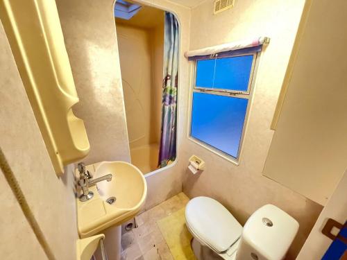 a bathroom with a sink and a toilet and a window at Your Camp Hel Holender in Hel