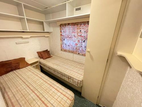 a small room with two beds and a window at Your Caravan Hel in Hel