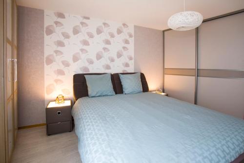 une chambre avec un lit avec une couette bleue dans l'établissement LE ST JOSSE GITE TOUT CONFORT A COLMAR, à Colmar