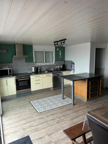 - une cuisine avec une table au milieu d'une pièce dans l'établissement La Villa, à Meschers-sur-Gironde