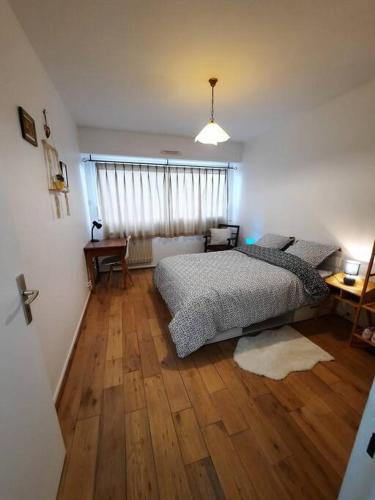 une chambre avec un lit et un parquet dans l'établissement Chez Alice, à Colmar