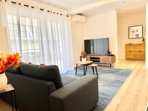 a living room with a couch and a flat screen tv at House climatisée & parking à 15 minutes de Paris in Bagneux