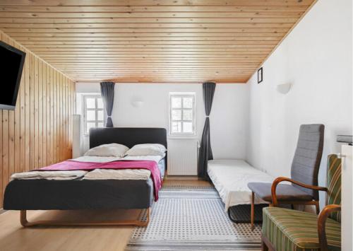 a bedroom with two beds and a couch in it at Cosy private room in Slagelse