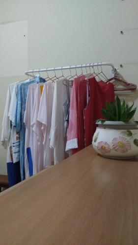 Un tas de vêtements sont suspendus sur un portant. dans l'établissement Casa no Feitosa Maceio, à Maceió