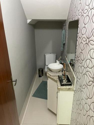 a small bathroom with a sink and a mirror at Cidade Nova, Gov. Valadares in Governador Valadares