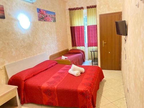 a hotel room with two beds and a television at Roma Guest House in Rome