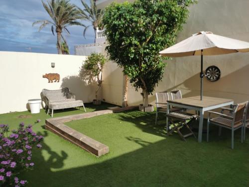 une terrasse avec une table, des chaises et un parasol dans l'établissement Casa La Buena Ola, à Playa del Hombre