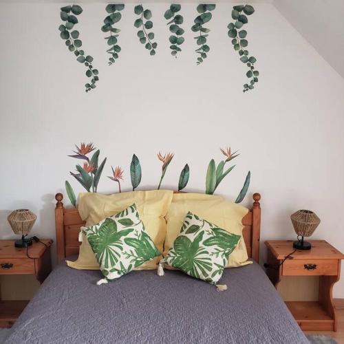 a bedroom with a bed with plants on the wall at Maison de la plage 