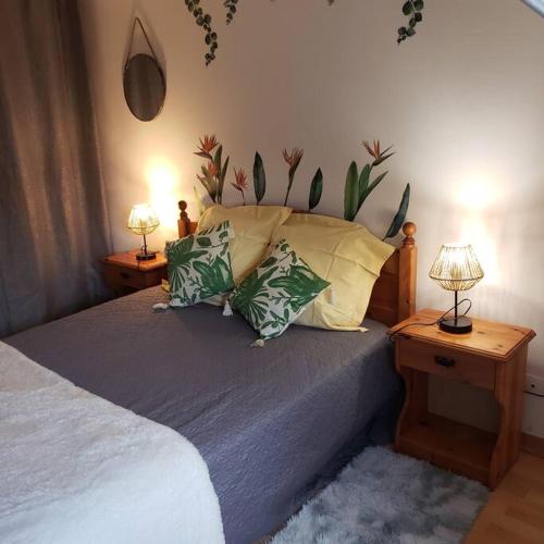 ein Schlafzimmer mit einem Bett mit Kissen und zwei Lampen in der Unterkunft Maison de la plage 