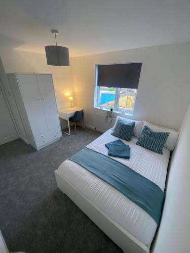 a bedroom with a bed and a desk and a window at Erin Guest House in Bristol