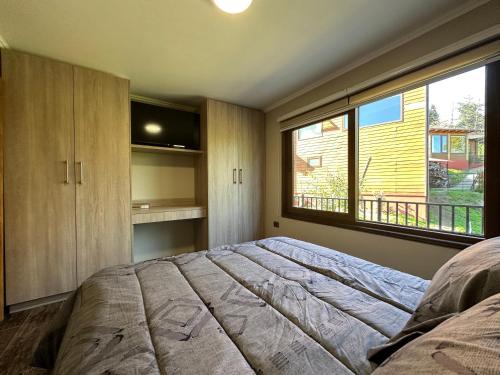 オソルノにあるmirabosque aparment ejecutivo 5のベッドルーム(大型ベッド1台、大きな窓付)