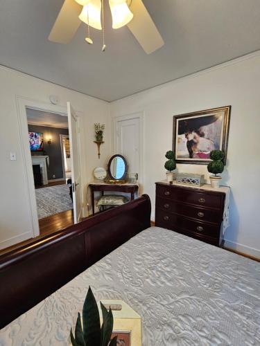 Schlafzimmer mit einem Bett, einer Kommode und einem Spiegel in der Unterkunft Secluded English Retreat by Rice, Medical Center & Museum District in Houston
