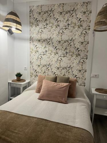 una camera da letto con un letto con carta da parati floreale di Estudios Los Sueños de Ana a Jerez de la Frontera