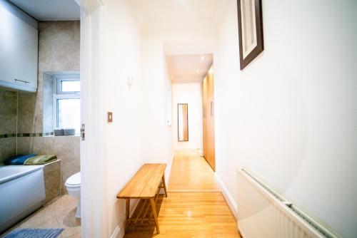 a hallway with a wooden table in a bathroom at Stay with Serena Homes , One bedroom apartment in Purley