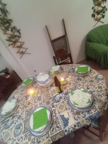 a table with green plates and candles on it at O Mundo da Lua in Azeitao