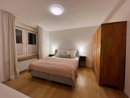 a bedroom with a large bed and two windows at Stilvolles Ferienhaus in Gerolstein in Gerolstein