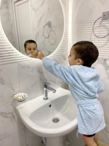 a young child standing in front of a bathroom mirror at Yeghevni Guest House in Odzun in Odzun