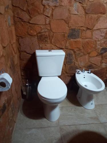 a bathroom with a white toilet and a sink at Cabañas Misioneras in San Ignacio