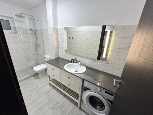 a bathroom with a sink and a washing machine at 1 Mai - Luxury Park Apartments - Self Check-in - Private parking - 2 in Craiova