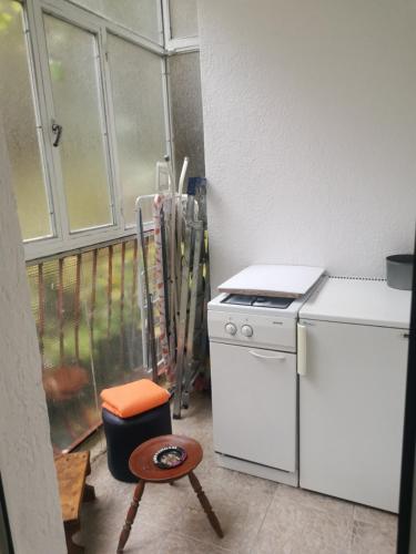 cocina con fogones y taburete junto a una ventana en Apartman Mirka 2, en Karaburma