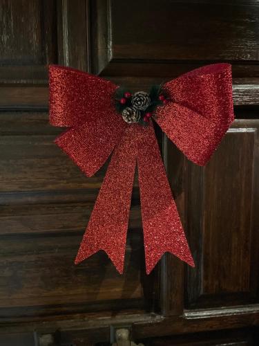 a red bow hanging on a wooden door at My Sweet Home in Tríkala