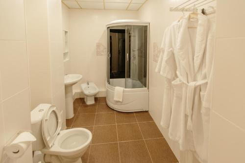 タンボフにあるHotel Grand Tambovの白いバスルーム(トイレ、シャワー付)