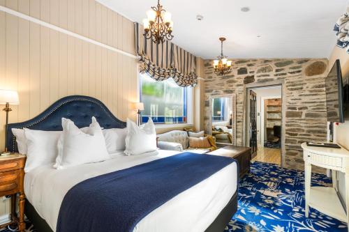 a bedroom with a large bed and a stone wall at Hulbert House Luxury Boutique Lodge Queenstown in Queenstown