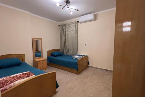 um pequeno quarto com 2 camas e um espelho em Modern and cozy apartment no Cairo