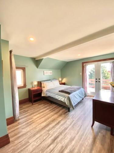 a bedroom with a large bed and a wooden floor at Cozy Suite-Walk to the Falls! in Niagara Falls