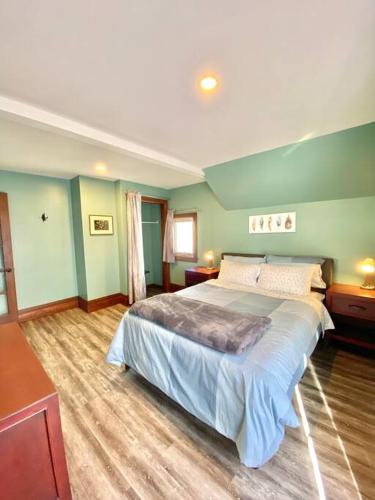 a bedroom with a large bed and green walls at Cozy Suite-Walk to the Falls! in Niagara Falls