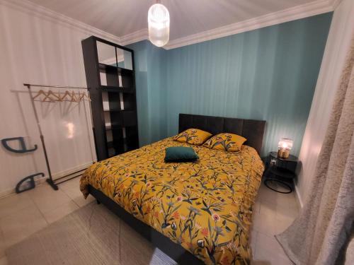 une chambre avec un lit avec une couverture jaune dans l'établissement Bienvenue chez ANOUK, à Châlons-en-Champagne