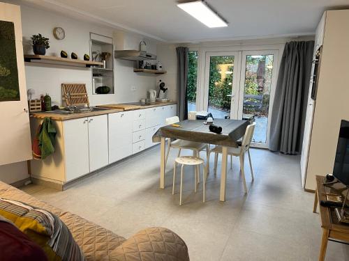 uma cozinha com mesa e cadeiras num quarto em Studio renové rdc terrasse wépion (Namur) em Namur