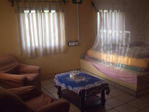 a living room with a bed and a table at Camping-Sukuta & Lodge in Sukuta