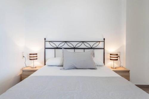 a bedroom with a large white bed with two lamps at Patacona Penthouse SeaView in Valencia