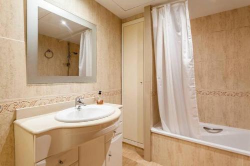 bagno con lavandino, vasca e specchio di Patacona Penthouse SeaView a Valencia