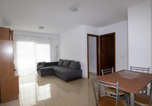 ein Wohnzimmer mit einem Sofa und einem Tisch in der Unterkunft Vivienda vacacional Rous in Los Llanos de Aridane
