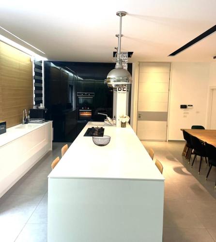 eine Küche mit einer weißen Theke und einem Esszimmer in der Unterkunft בית פרטי מדהים עם ממ"ד במושב פסטורלי ליד תל אביב in Mazor
