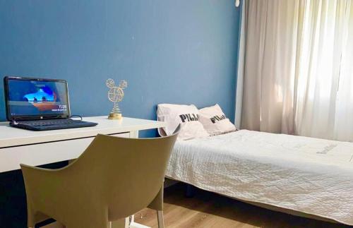 Schlafzimmer mit einem Bett und einem Schreibtisch mit einem Laptop in der Unterkunft בית פרטי מדהים עם ממ"ד במושב פסטורלי ליד תל אביב in Mazor