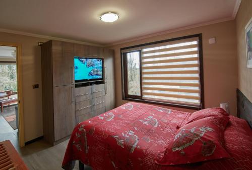 1 dormitorio con cama roja y TV en mirabosque new aparments 4, en Osorno