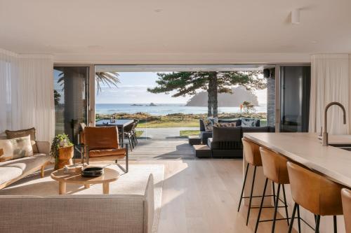 an open kitchen and living room with a view of the ocean at 36 Marine - Unparalleled beachfront luxury in Mount Maunganui