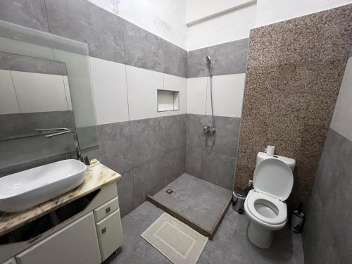 a bathroom with a toilet and a sink at África em Zona Comercial de Luanda in Luanda