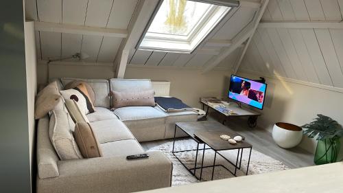 - un salon avec un canapé et une fenêtre dans l'établissement Bij Risje dorp, à Ballum